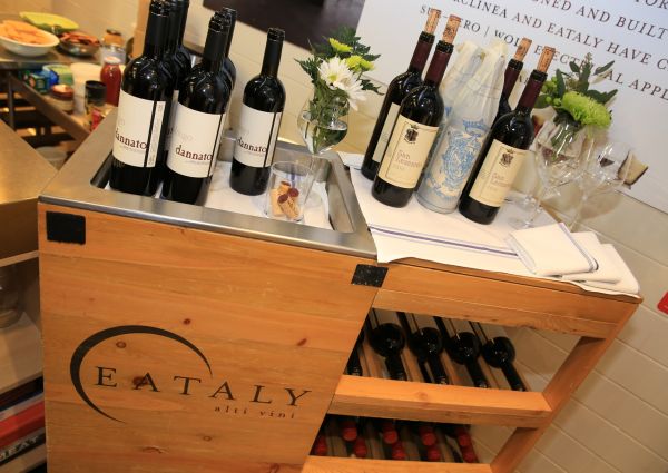 Trentino wines at Eataly NY. Bottles of red wine on a wooden cart with the Eataly logo. Wine tasting.