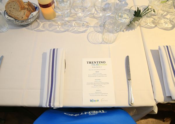 Table setting at Eataly NY for Trentino Film & Food event. Menu, glassware, bread, and striped napkins.