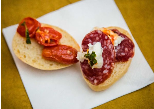 Italian cacciatore panino. Salami and tomato bruschetta on a white napkin.
