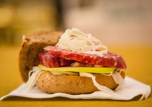 Italian Cacciatore sandwich. Panino Tedesco with salami, apple, and sauerkraut on a bun. International cuisine.