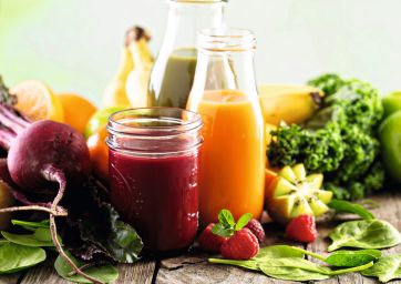 Fresh vegetables and fruits juices with beets, berries, oranges and greens