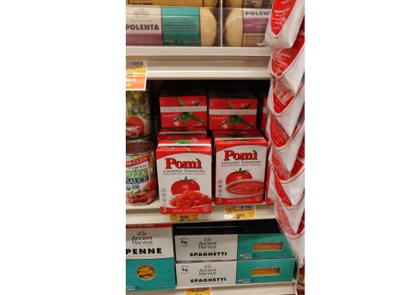 Safeway shelf with Italian food: pasta, polenta, tomato sauce, and Pomi chopped and strained tomatoes.