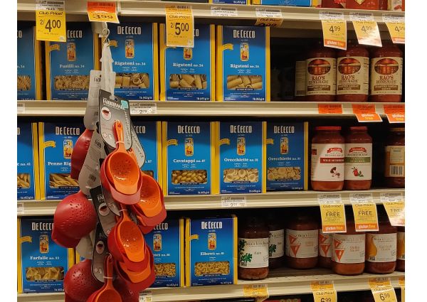 Safeway Italian food aisle: De Cecco pasta boxes, Rao's & Mia's Kitchen sauces. Colanders hanging on display.