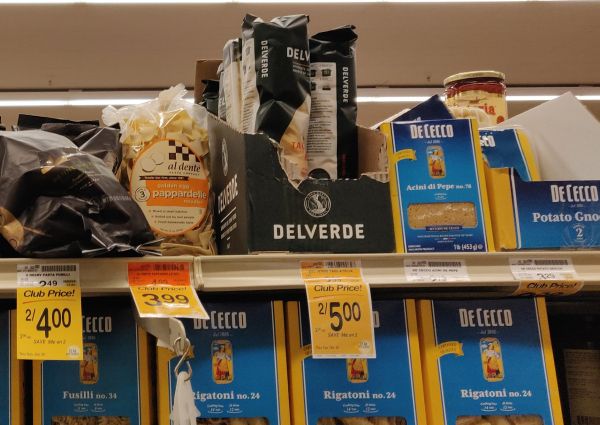 Italian pasta products on a Safeway shelf. De Cecco, Delverde, and Al Dente brands. Rigatoni, fusilli, pappardelle.