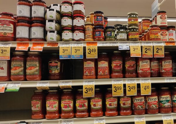 Safeway Italian food aisle. Pasta sauces and pesto jars on shelves. Brands include Bertolli, Prego, Classico, and Rao's.