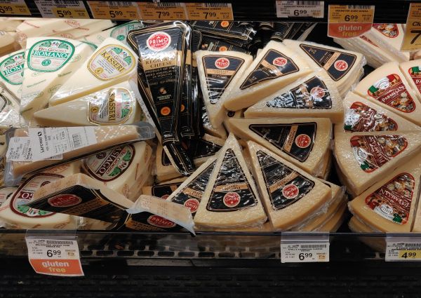 Italian cheeses on display at Safeway. Primo Reggiano, BelGioioso Romano, Kasseri, and Asiago cheese wedges.