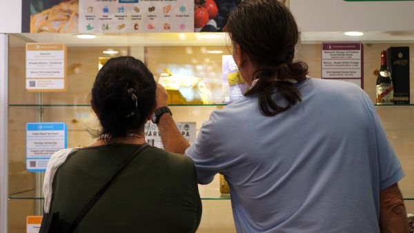 Attendees at Italian Food Awards USA 2019 viewing award-winning Italian food products in a display case.
