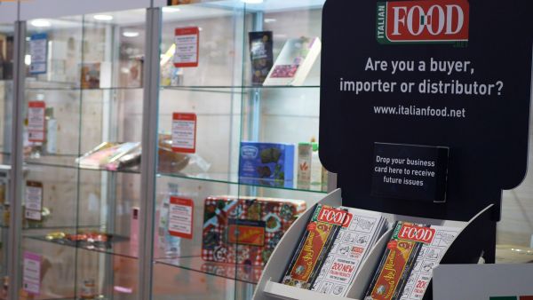 Italian Food Awards USA 2019 display. Italian food products in glass cases, brochures, and promotional signage.