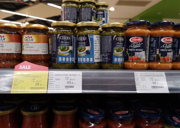 Shelves of pasta sauces: Cirio pesto, Barilla pesto rosso, Sacla tomato & garlic. High-end Shanghai grocery store.