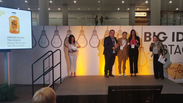 Italian Food Awards USA 2019 winners on stage. People holding awards. San Benedetto tea on screen.