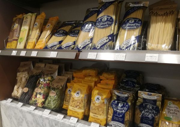 Shelves of Italian pasta in a Tokyo store. Fantasie del Grano, Inaudi Cav. Cocco, and Alce Nero brands. Spaghetti, fusilli, penne rigate.