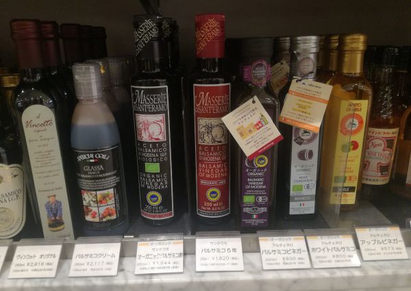 Italian balsamic vinegar & glazes on display in a Tokyo store. Organic Modena vinegar bottles on a shelf. Food and beverage.