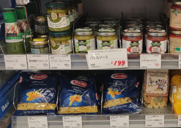 Italian food aisle in Osaka, Japan. Pesto, pasta sauce, Barilla pasta, and Mickey Mouse pasta on display. Italian cuisine.