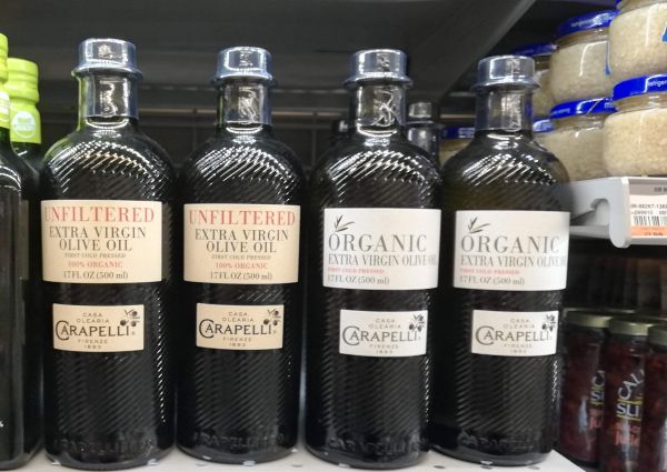 Carapelli extra virgin olive oil bottles on a shelf at Heirloom Market.