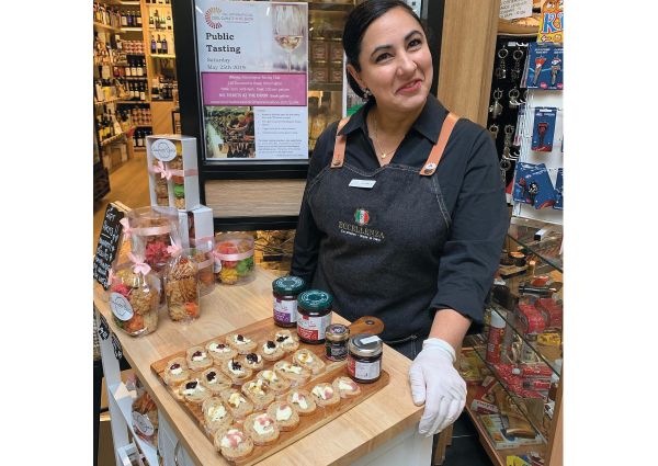 Eccellenza Italian foods tasting. Woman in apron with Italian appetizers and jams. Authentic Italian cuisine in Australia.
