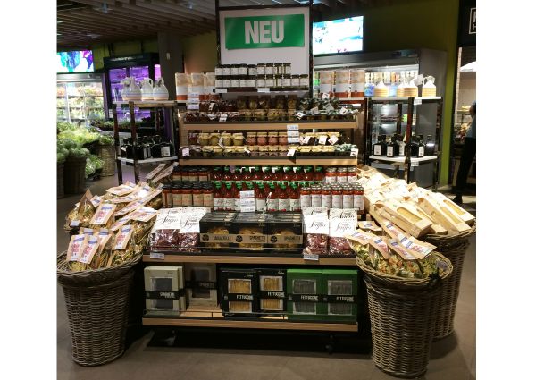 Italian food display at Migros. Atlante brings Little Italy to Swiss stores with pasta, sauces, and preserves.