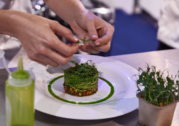 Chef plating pasta dish at Barilla Master of Pasta competition. Fine dining cuisine.