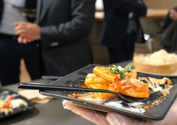 Italian pasta dish. Tariffs impact food costs. Rigatoni with tomato sauce and basil. Food industry concerns.