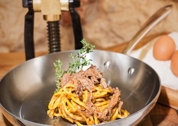 Bigoli pasta with meat sauce in a pan. Traditional Italian dish.
