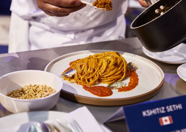 Barilla Master of Pasta dish. Spaghetti with tomato sauce and fish. Chef plating pasta.