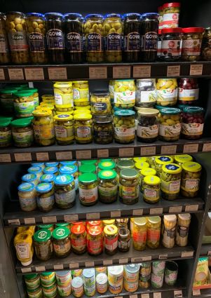 Shelves of Italian appetizers: olives, pickles, asparagus, and more in jars. Italian food store in Seoul.