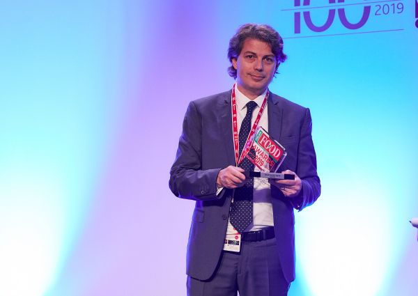 Italian Food Awards 2019 winner. Man in suit holding award.