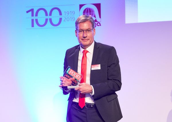Man holding Italian Food Awards 2019 trophy. Award winner in suit and red tie.