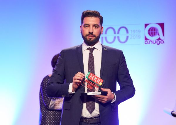 Italian Food Awards 2019 winner. Man in suit holding award.