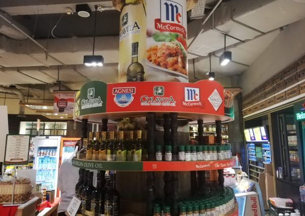 99 Ranch Market display of Colavita olive oil, McCormick spices, and Tabasco sauce products. Grocery shopping in Jakarta.
