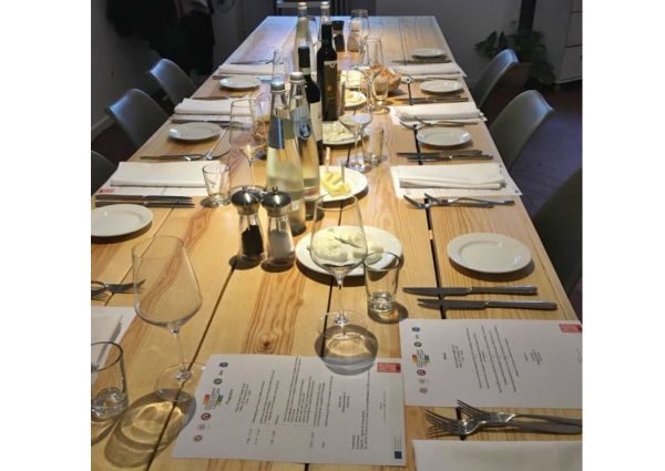 European Quality Food: Long table set for an Italian food event in Berlin, Germany. Plates, wine, water, menus.