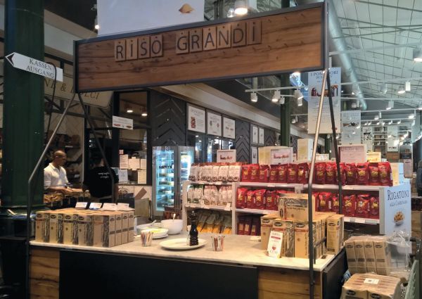 Italian rice variety: Riso Grandi display. Shelves of pasta and rice products in a market setting.