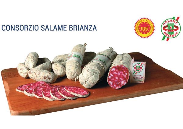Salame Brianza PDO. Italian cured sausage on a wooden board, whole and sliced. Traditional dry salami.