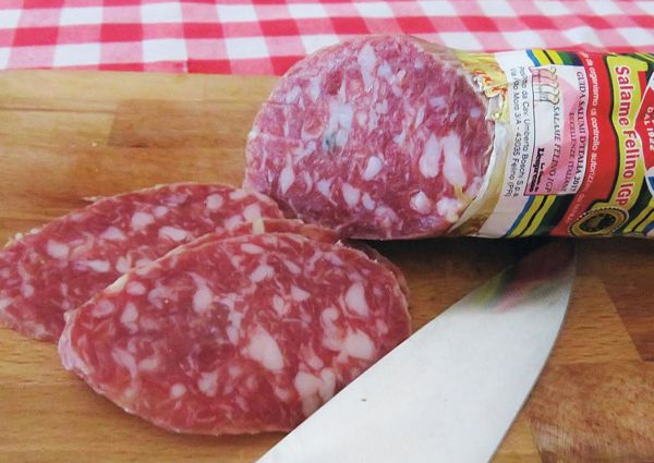 Salame Felino IGP, an Italian PDO salami, sliced on a wooden board. Popular cured meat.