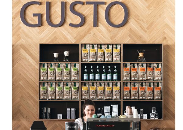 Italian cafe Gusto in Australia. Shelves of European foods, coffee, and beverages. Barista at counter.