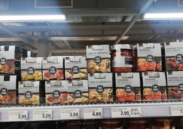 Coop Suisse Italian Fine Food products on shelves. Jars and boxes of bruschetta, artichoke hearts, olive and tomato creams.