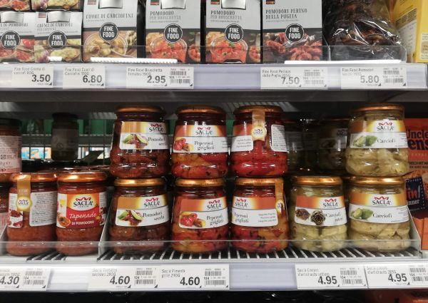 Saclà vegetable preserves on display at Coop Suisse. Jars of Italian food: tapenade, artichokes, peppers, and dried tomatoes.