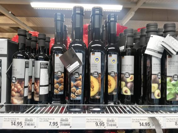 Coop Suisse Italian food: Selection of Fine Food oils (hazelnut, walnut, pumpkin seed, avocado, olive) on store shelf.
