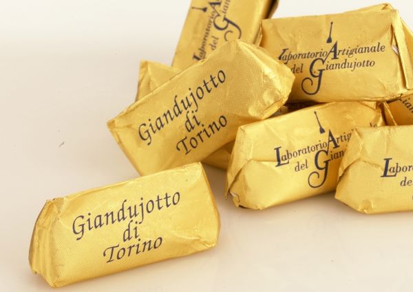 Wrapped Gianduiotto chocolates. Turin's traditional hazelnut sweets in gold foil. Italian confectionery.