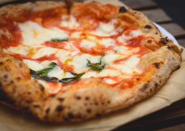 Close-up of a delicious Neapolitan pizza with tomato sauce, mozzarella, and basil.