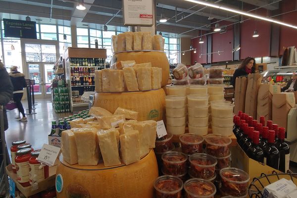 Italian food display at Whole Foods Market. Features Parmigiano Reggiano cheese, sauces, and wine.