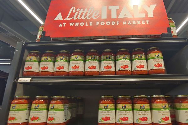 Whole Foods Market: Shelves of 365 Organic pasta sauce (marinara, tomato basil, Italian herb). A Little Italy sign.