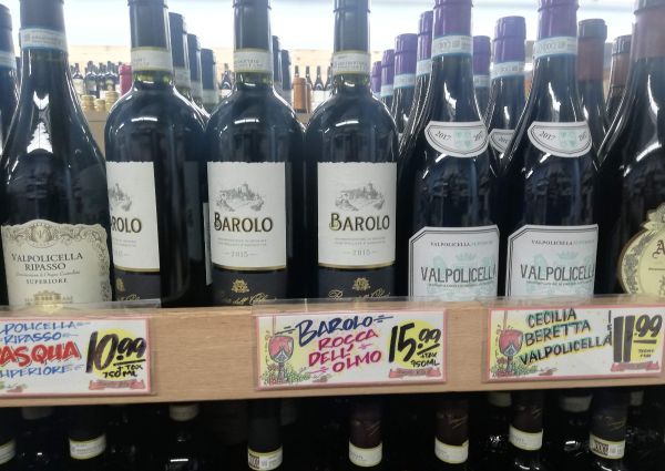 Trader Joe's Italian wine selection: Barolo, Valpolicella. Bottles of red wine on a shelf with price tags.