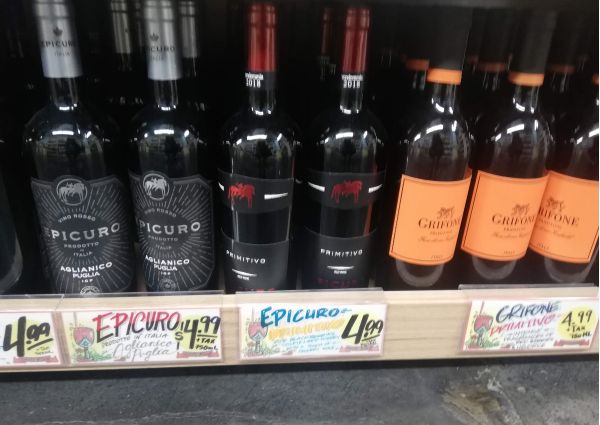 Italian wine selection at Trader Joe’s: Aglianico, Primitivo, and Grifone. Red wine bottles on a shelf with price tags.