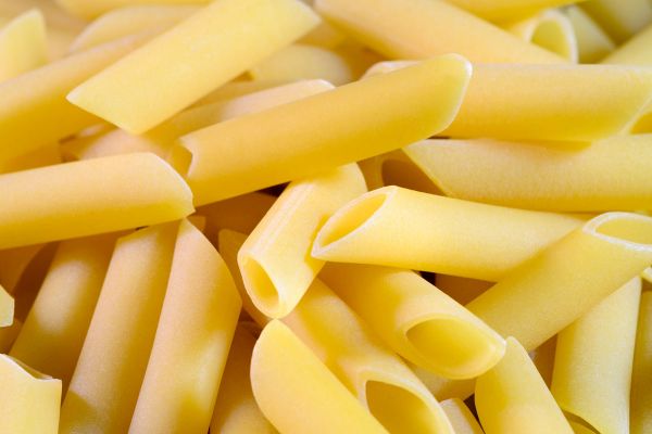 Close-up of Penne Lisce Pasta. Italian cuisine ingredient. Losers and winners of COVID-19.