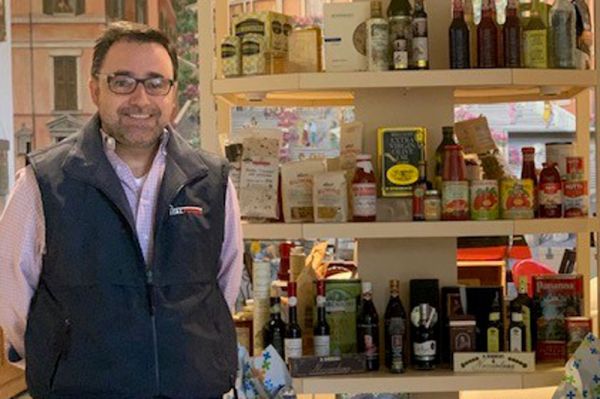 Richard Armanino, US distributor of Italian food products, stands in front of shelves stocked with Italian goods.