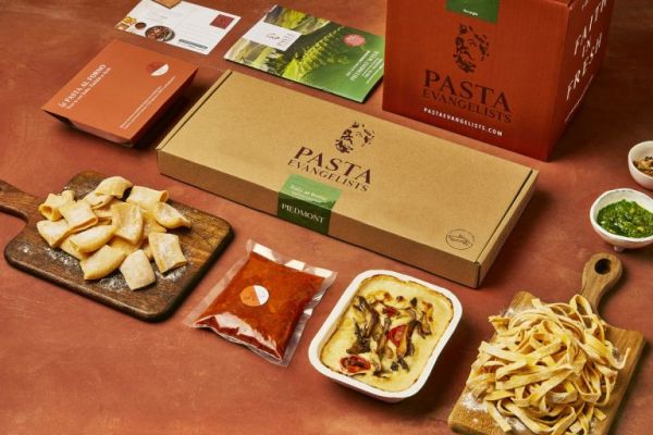Pasta Evangelists meal kit. Fresh pasta, sauce, and baked pasta dish on a table.