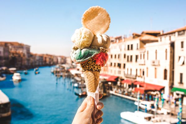 Italian ice cream gelato cone in Venice, Italy. Delicious dessert with colorful scoops and a wafer.