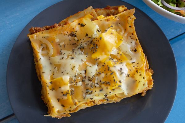 Lasagna on plate. Super Bowl food, pasta dish with cheese and herbs. Italian cuisine.