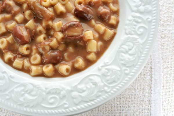 Pasta e fagioli soup in a white bowl. Italian comfort food with ditalini pasta and beans. Popular Super Bowl food.