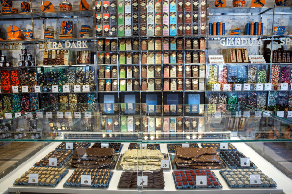 Venchi chocolate shop display. Rows of chocolates, bars, and candies. Retail sales are up in the US.